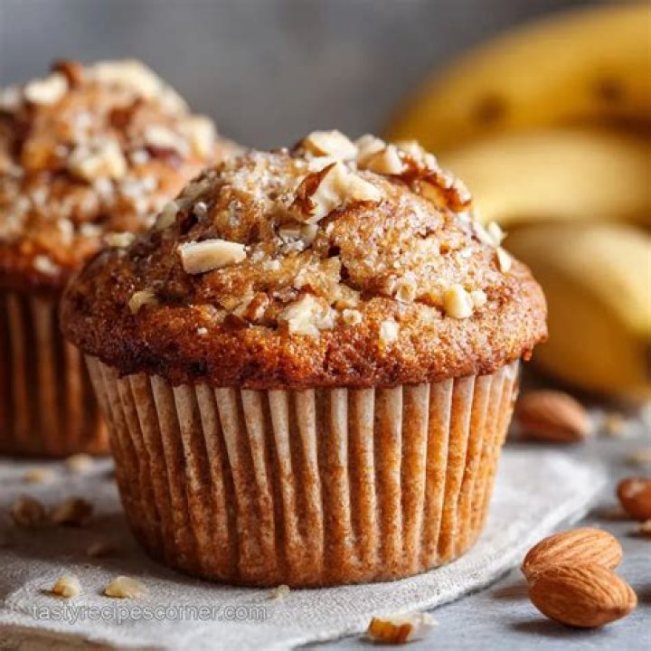 Banana nut muffin topped with brown sugar and nuts.