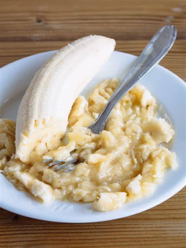 Mashed bananas in a white bowl.